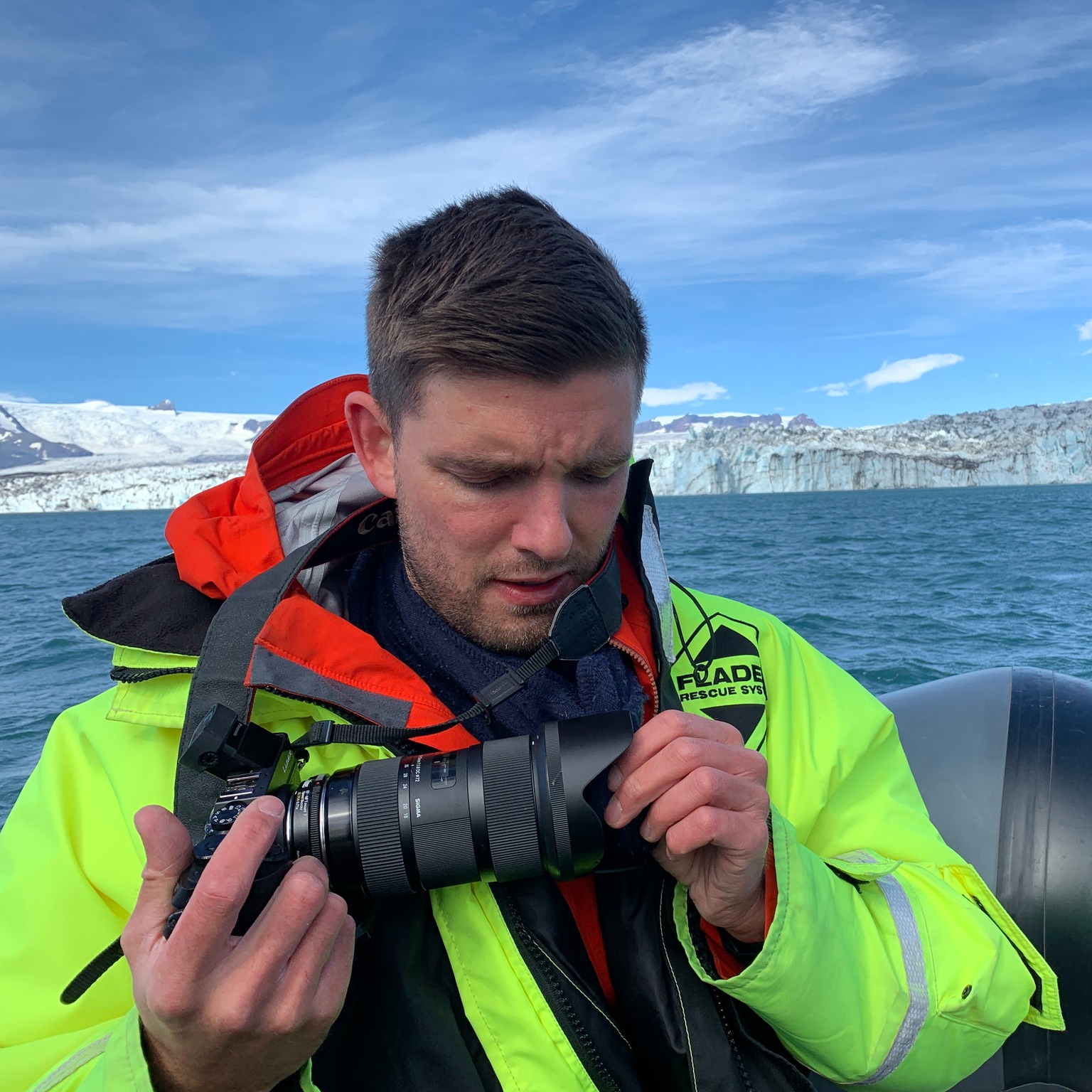 Bjarki Bragason on a boat, fiddling with his camera. 